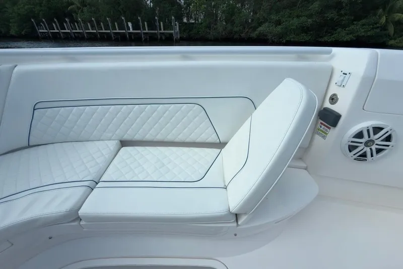  Yacht Photos Pics 2022 Intrepid 407 Panacea boat seating with white quilted upholstery and speaker.