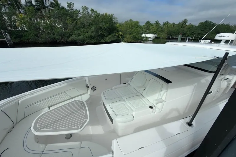  Yacht Photos Pics 2022 Intrepid 407 Panacea boat with shaded seating area and sleek design.