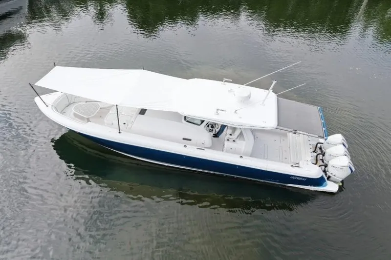  Yacht Photos Pics 2022 Intrepid 407 Panacea boat with canopy, docked on calm water.