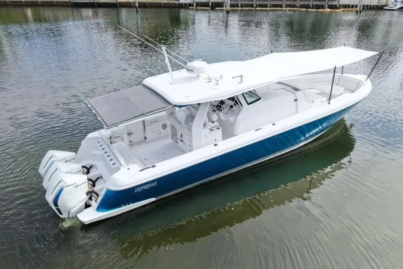  Yacht Photos Pics 2022 Intrepid 407 Panacea boat with triple engines, docked on calm water.