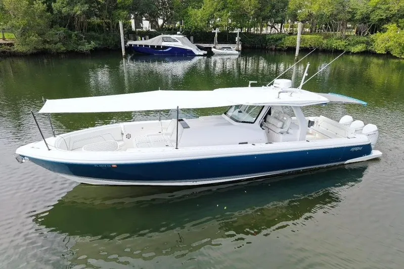  Yacht Photos Pics 2022 Intrepid 407 Panacea boat with canopy, docked on calm water.