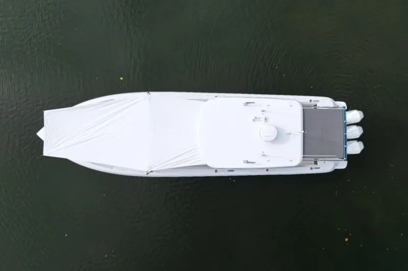  Yacht Photos Pics Aerial view of 2022 Intrepid 407 Panacea boat on water, covered with a white tarp.