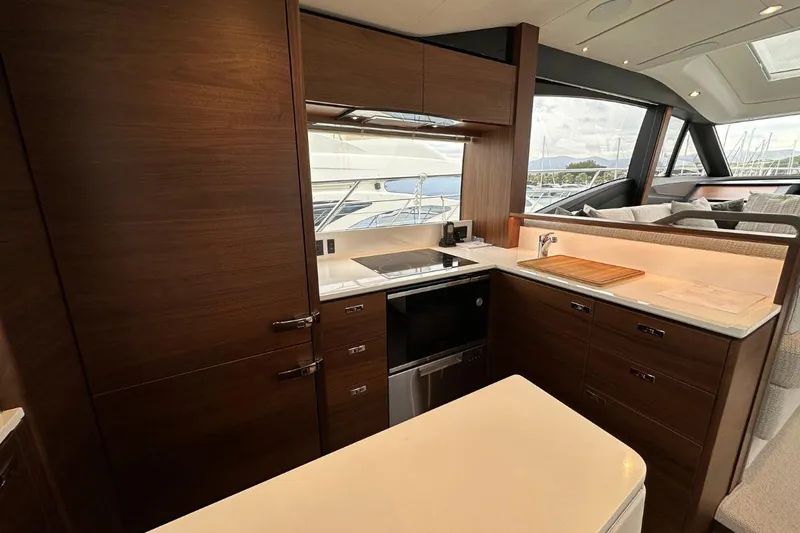 Yacht Photos Pics Luxurious kitchen interior of 2023 Princess S62 yacht with modern wood cabinetry and appliances.
