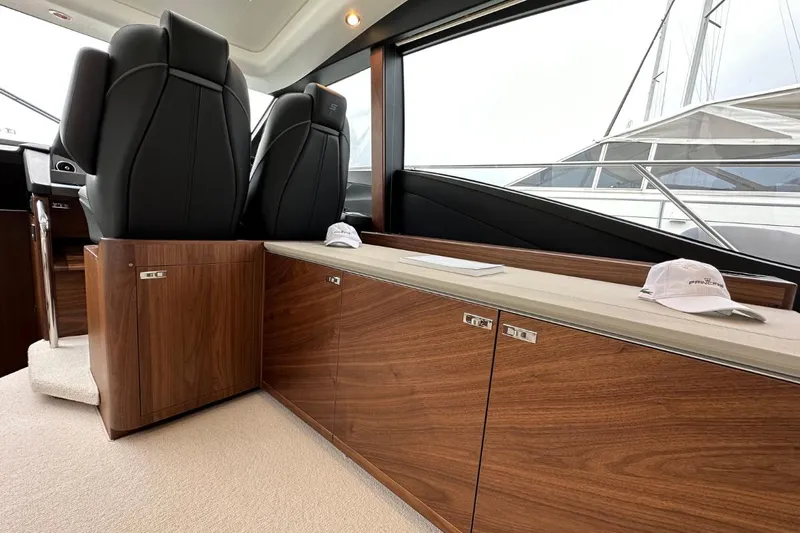  Yacht Photos Pics Luxurious interior of 2023 Princess S62 yacht with sleek wood cabinetry and modern seating.