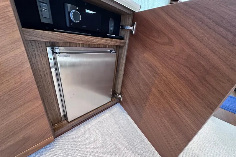  Yacht Photos Pics Wooden cabinet with integrated Vitrifrigo fridge in 2023 Princess S62 yacht interior.