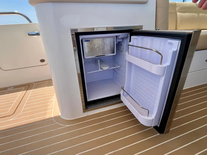 Waterlee Yacht Photos Pics Open mini fridge on 2019 MJM 35z boat, showcasing interior storage space.