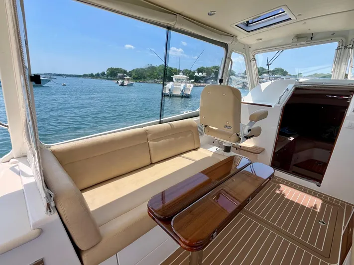 Waterlee Yacht Photos Pics Interior of 2019 MJM 35z yacht with seating and table, overlooking a scenic waterfront.