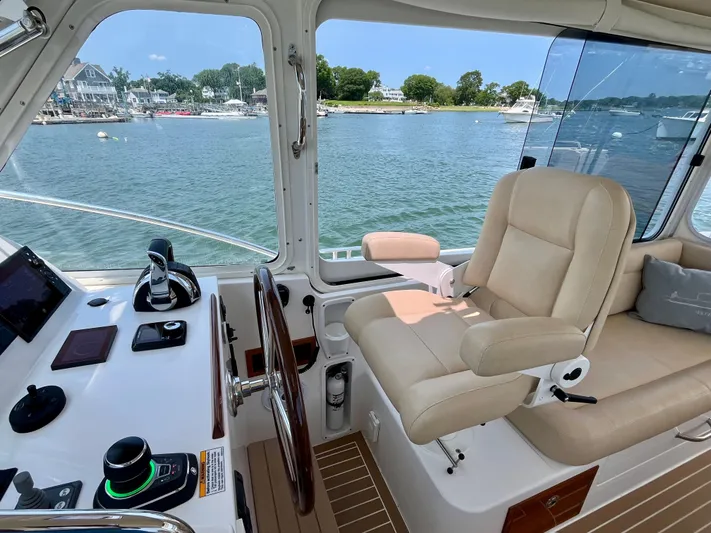 Waterlee Yacht Photos Pics 2019 MJM 35z boat helm with beige seating, overlooking serene waterfront.