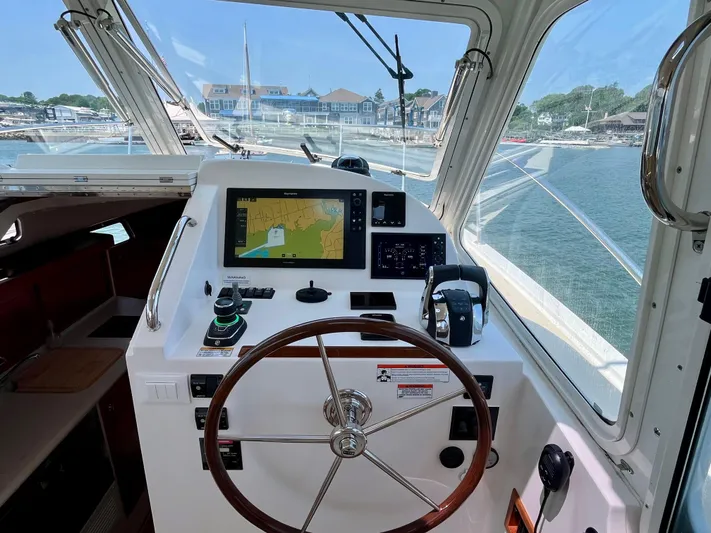 Waterlee Yacht Photos Pics Helm of 2019 MJM 35z boat with navigation display, steering wheel, and marina view.