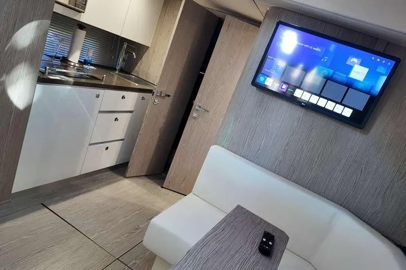  Yacht Photos Pics 2024 Sessa Marine C44 Cruiser interior with modern kitchen and wall-mounted TV.