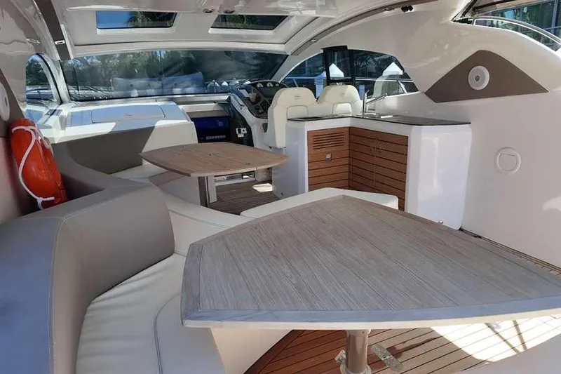  Yacht Photos Pics Interior of 2024 Sessa Marine C44 Cruiser with modern seating and wooden tables.