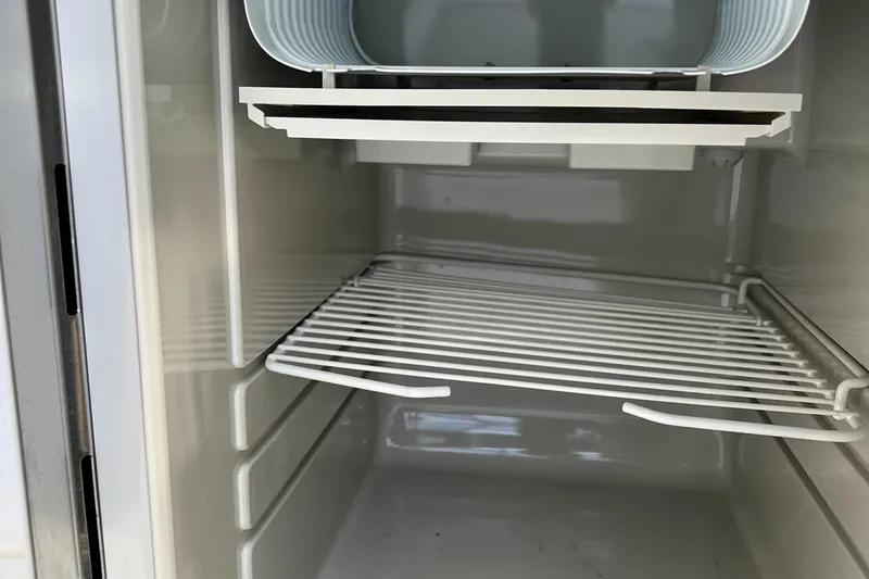  Yacht Photos Pics 2015 Hunt Yachts Harrier Sport refrigerator interior with wire shelf and storage compartment.