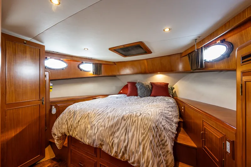 Moore Fun Yacht Photos Pics Luxurious 1998 Ocean Alexander 486 Classico Pilothouse bedroom with wood paneling and cozy bedding.