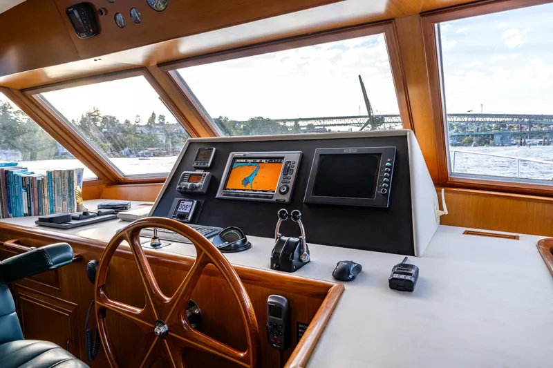 Moore Fun Yacht Photos Pics Pilothouse interior of 1998 Ocean Alexander 486 Classico, featuring navigation equipment and wooden steering wheel.