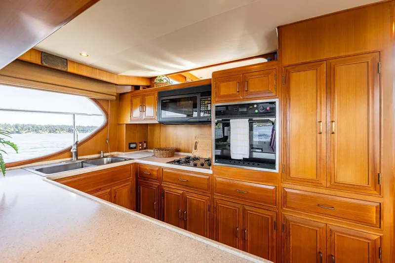 Moore Fun Yacht Photos Pics Luxurious 1998 Ocean Alexander 486 Classico Pilothouse kitchen with wood cabinetry and modern appliances.