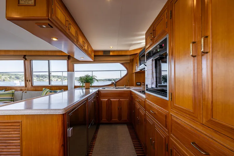 Moore Fun Yacht Photos Pics Luxurious 1998 Ocean Alexander 486 Classico Pilothouse kitchen with wooden cabinetry and scenic windows.