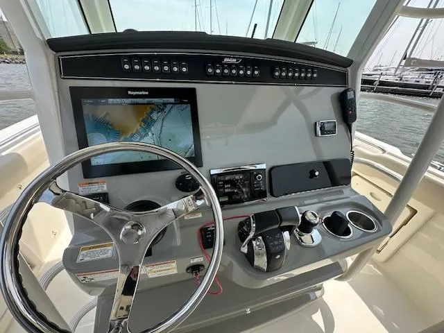 Boston Whaler 330 Outrage Yacht Photos Pics Control panel of 2016 Boston Whaler 330 Outrage with navigation screen and steering wheel.