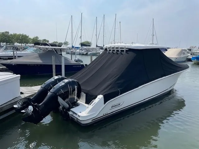 Boston Whaler 330 Outrage Yacht Photos Pics 2016 Boston Whaler 330 Outrage boat docked with cover, featuring twin outboard engines.