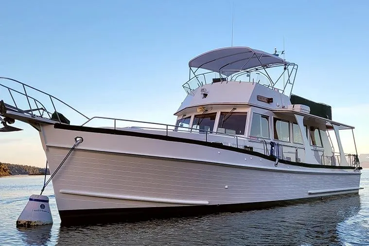 Goodlife Yacht Photos Pics 1998 Grand Banks 46 Europa yacht on calm water at sunset.