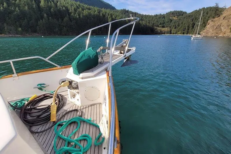 Goodlife Yacht Photos Pics 1998 Grand Banks 46 Europa yacht anchored in scenic bay with lush forest backdrop.