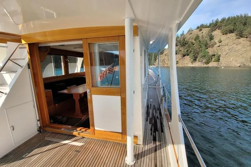 Goodlife Yacht Photos Pics 1998 Grand Banks 46 Europa yacht with wooden interior, docked by scenic waterside.