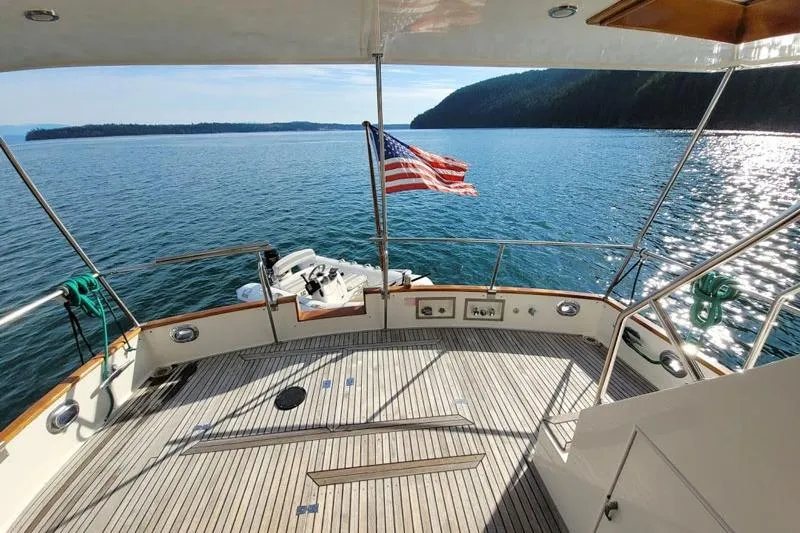 Goodlife Yacht Photos Pics 1998 Grand Banks 46 Europa yacht deck with American flag, overlooking serene waters.