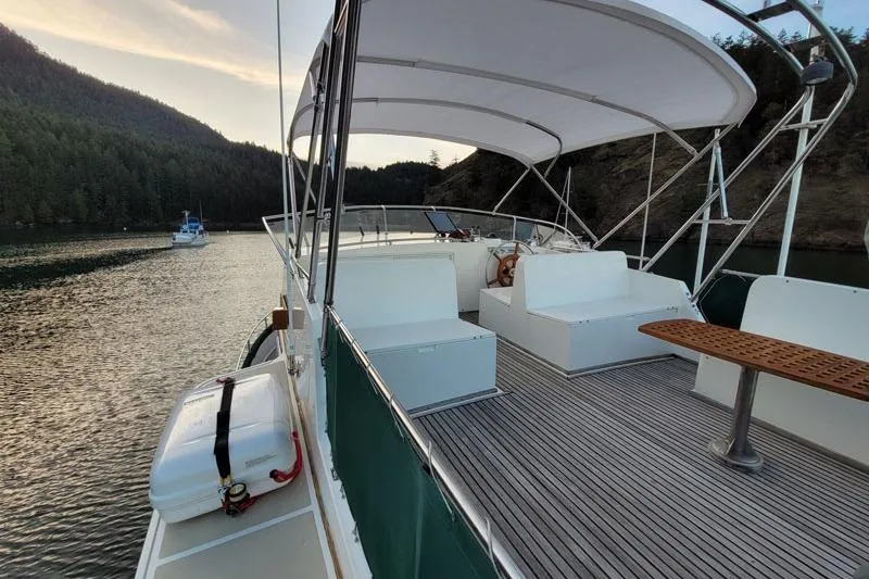 Goodlife Yacht Photos Pics 1998 Grand Banks 46 Europa yacht with spacious deck and canopy, docked in scenic waters.