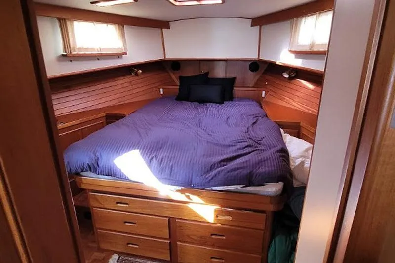 Goodlife Yacht Photos Pics Cozy bedroom in 1998 Grand Banks 46 Europa yacht with wooden cabinetry and blue bedding.