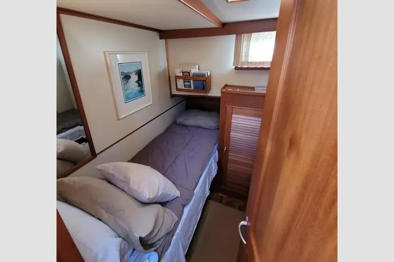 Goodlife Yacht Photos Pics Cozy cabin interior of 1998 Grand Banks 46 Europa yacht with bed and wooden furnishings.