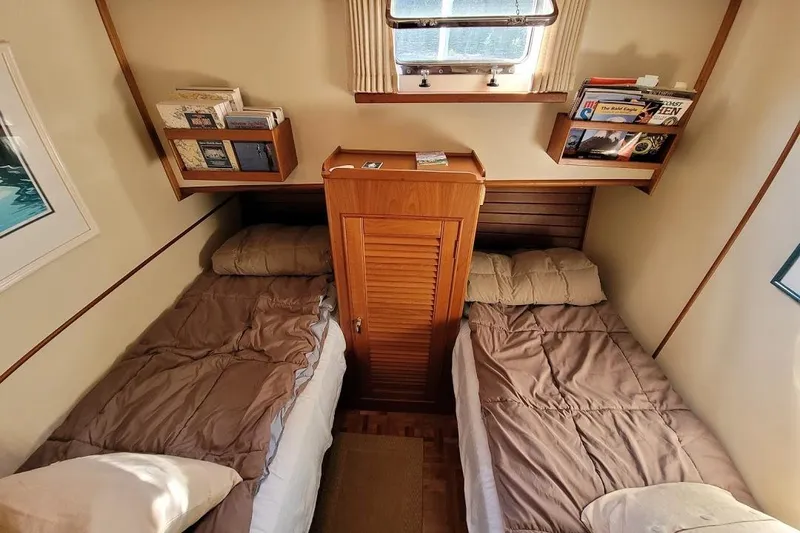 Goodlife Yacht Photos Pics Cozy twin cabin on 1998 Grand Banks 46 Europa yacht with bookshelves and window.
