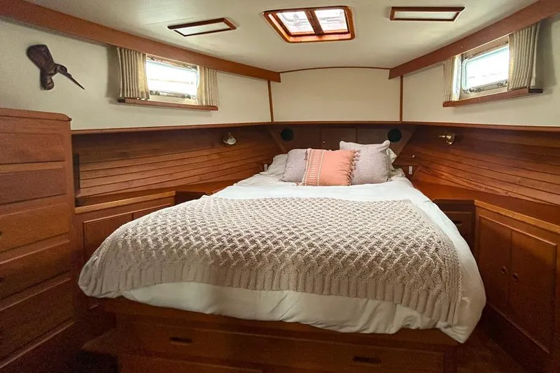 Goodlife Yacht Photos Pics Cozy cabin interior of 1998 Grand Banks 46 Europa with wooden finish and comfortable bedding.