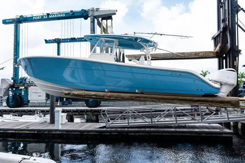  Yacht Photos Pics 2021 Cobia 350 Center Console boat in marina, elevated on lift, blue hull.