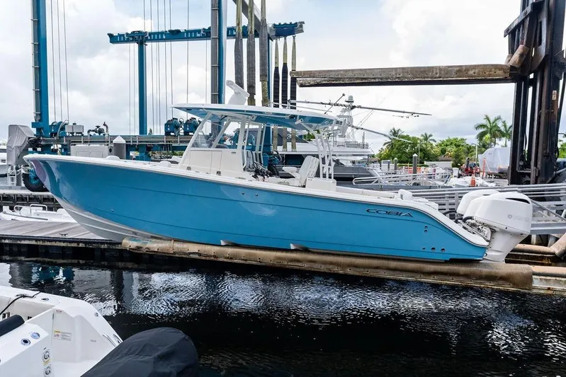  Yacht Photos Pics 2021 Cobia 350 Center Console boat in marina, featuring sleek blue design and powerful engines.