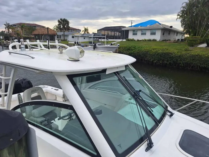  Yacht Photos Pics 2013 Boston Whaler 285 Conquest boat docked near waterfront homes.