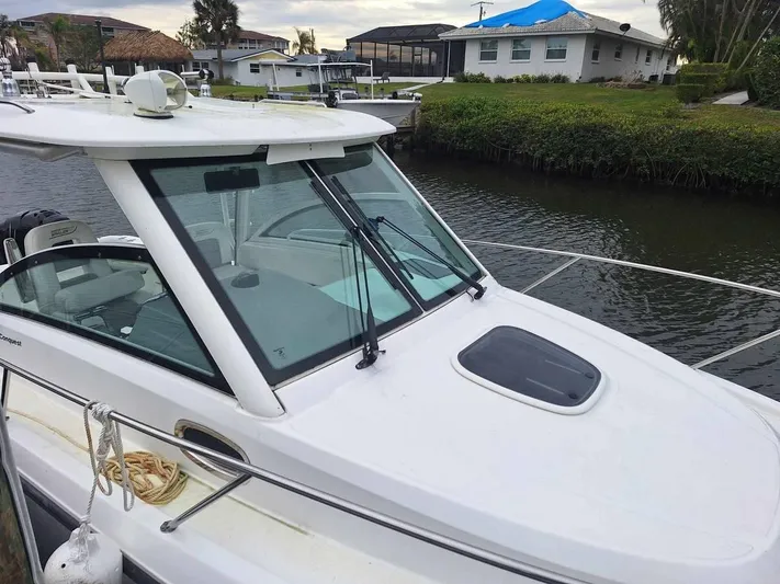  Yacht Photos Pics 2013 Boston Whaler 285 Conquest boat docked by a canal.