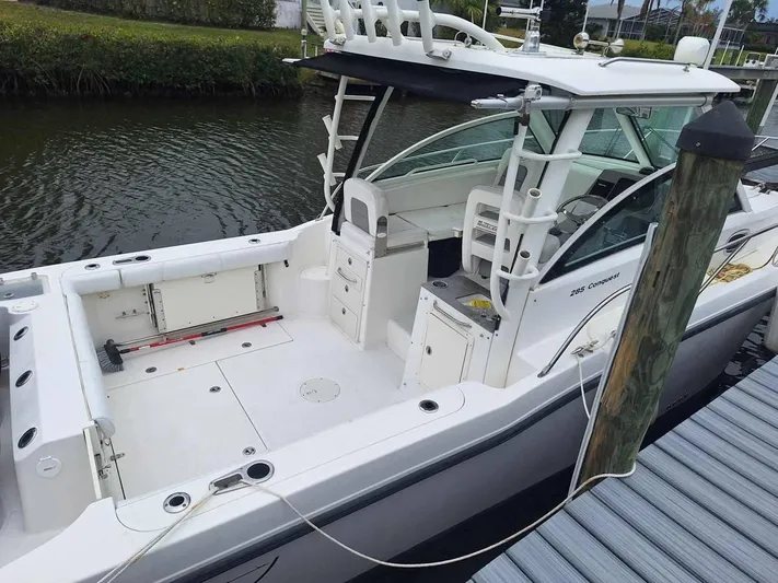  Yacht Photos Pics 2013 Boston Whaler 285 Conquest boat docked by a canal.