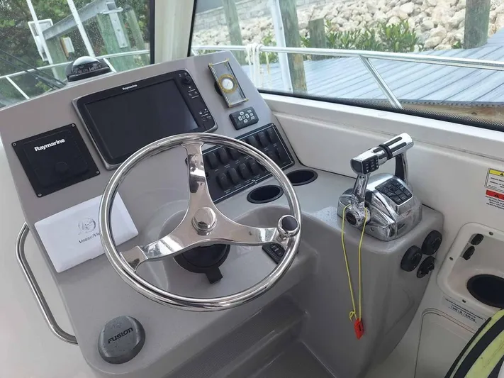  Yacht Photos Pics 2013 Boston Whaler 285 Conquest helm with steering wheel and navigation controls.