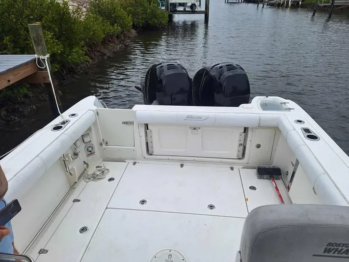  Yacht Photos Pics 2013 Boston Whaler 285 Conquest boat deck with twin outboard motors on a calm waterway.