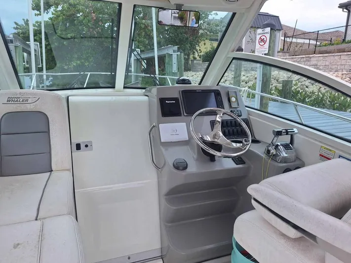  Yacht Photos Pics 2013 Boston Whaler 285 Conquest boat interior with steering wheel and navigation controls.