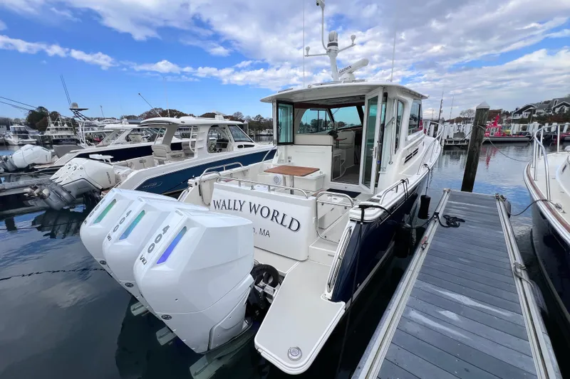 Wally World Yacht Photos Pics 2024 Back Cove 39O boat docked with triple outboard engines, under a partly cloudy sky.