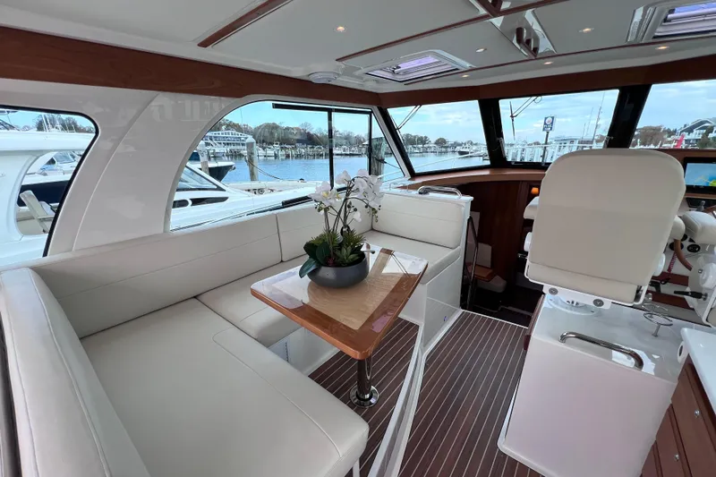 Wally World Yacht Photos Pics Luxurious interior of 2024 Back Cove 39O yacht with elegant seating and scenic marina view.