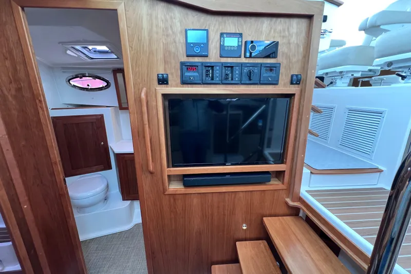 Wally World Yacht Photos Pics 2024 Back Cove 39O yacht interior with TV, control panel, and bathroom.