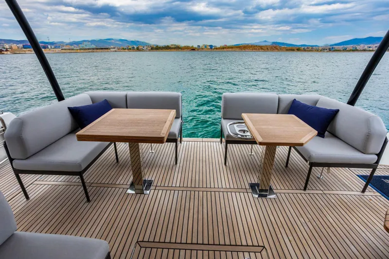  Yacht Photos Pics Luxurious 2024 Prestige M48 yacht deck with seating, tables, and ocean view.