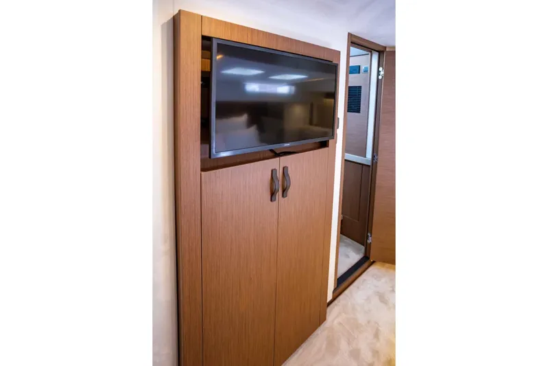  Yacht Photos Pics 2024 Prestige M48 yacht interior with wall-mounted TV and wooden cabinetry.