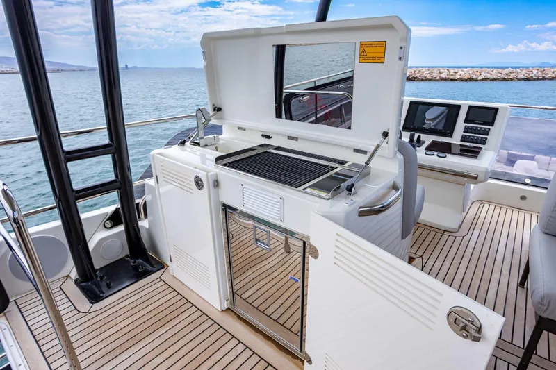  Yacht Photos Pics 2024 Prestige M48 yacht deck with grill and control panel, overlooking the ocean.