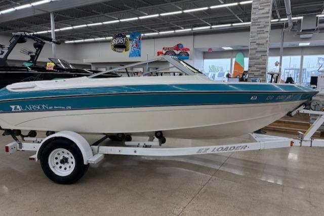 1991 Larson All American 170 boat on trailer in showroom.