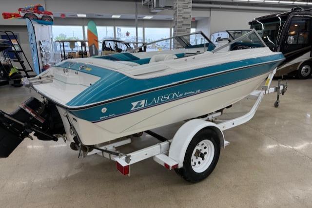 1991 Larson All American 170 boat on trailer in showroom.