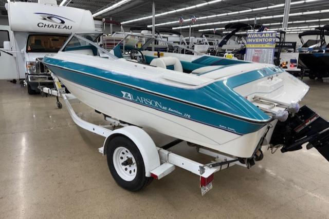 1991 Larson All American 170 boat on trailer in showroom, blue and white design.