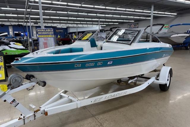 1991 Larson All American 170 boat on trailer in showroom.