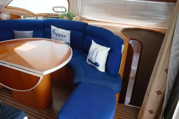 Jobsite Yacht Photos Pics Luxurious 2006 Alliaura Marine Privilege 435 EZC yacht interior with blue seating and wooden table.